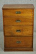 A Victorian campaign design bedside chest of four long graduated drawers with recessed handles, on a