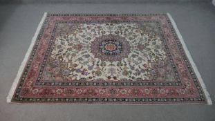 A Persian Keshan rug with central floral medallion on a biscuit ground within foliate spandrels