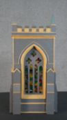 A scratch built matchstick model of a church tower, grey painted, with gothic arched stained glass