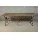A French wrought iron table, possibly a baker's table, with a rectangular metal top, on scrolling
