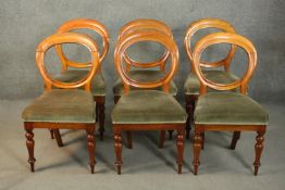 A set of six Victorian walnut balloon back dining chairs, upholstered in green velour, on turned