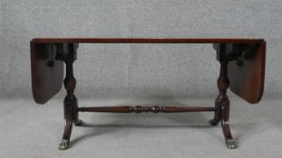 A 20th century George III style mahogany coffee table, the crossbanded top with two drop leaves,