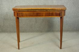 A Sheraton style mahogany card table, the rectangular top with canted corners, crossbanded with