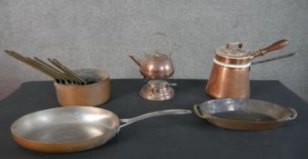 A collection of early 20th century copper ware, including a set of seven graduated copper and