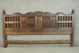 A Mexican stained pine super king size headboard, with turned finials, and a scrolling top, above