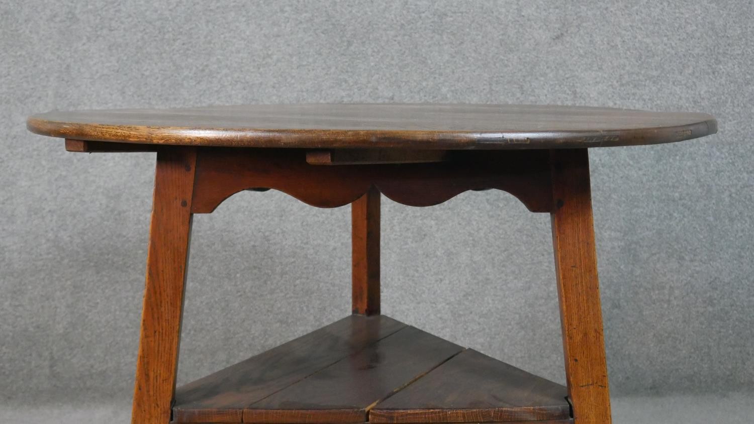 A 19th century country oak cricket table with shaped frieze on splay supports united by an - Image 2 of 5