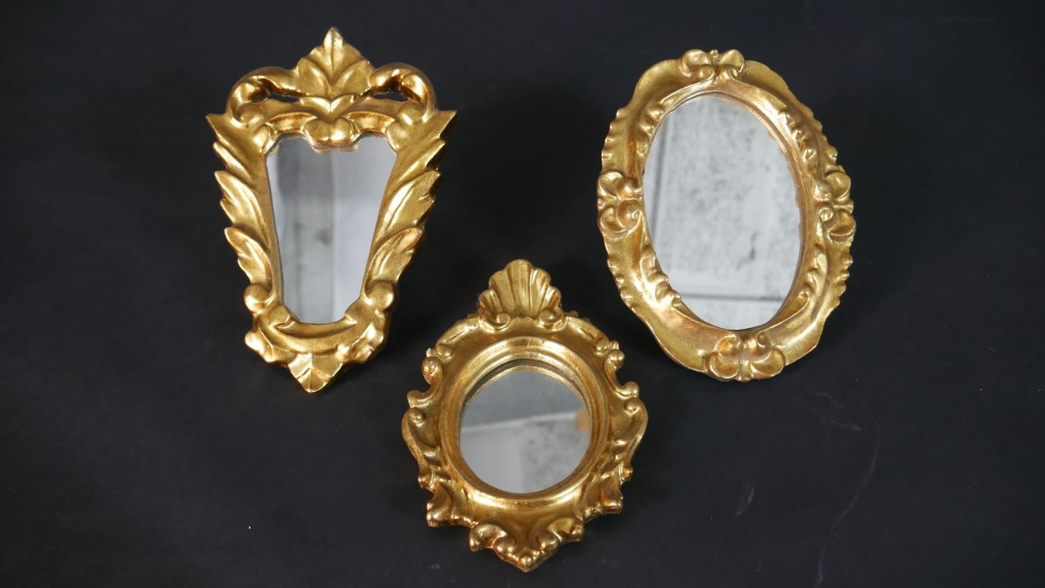 Three gilded gilt wood and gesso framed mirrors with foliate design. H.19 W.14cm (largest)