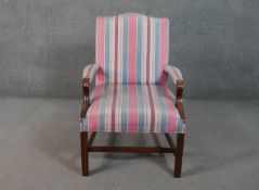 A mahogany Gainsborough style open armchair, upholstered in striped fabric to the back, seat and