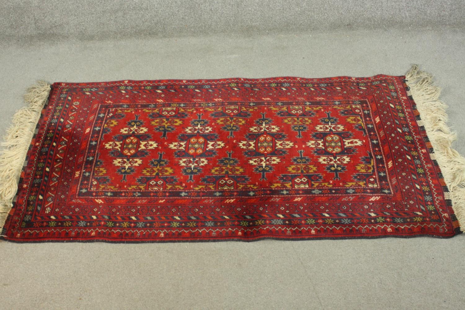 A hand made red ground Ankhoi Afghan rug. L.150 W.87cm.