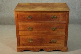 A 19th century chest of three long graduated drawers, with brass swing handles and backplates, on