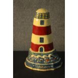 A painted cast iron door stop in the form of a lighthouse. H.34 W.23cm.