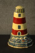 A painted cast iron door stop in the form of a lighthouse. H.34 W.23cm.
