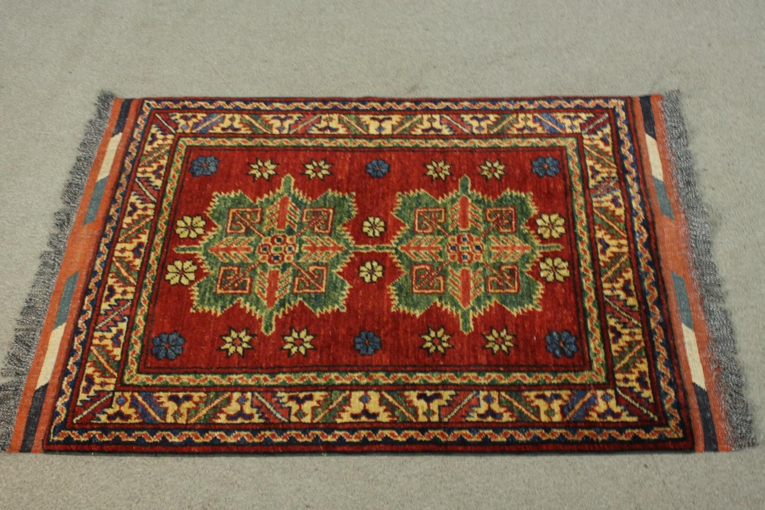 A hand made red ground Chechen rug. L.105 W.78cm.