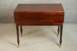 A George III mahogany Pembroke table, with drop leaves and an end drawer, on turned legs terminating