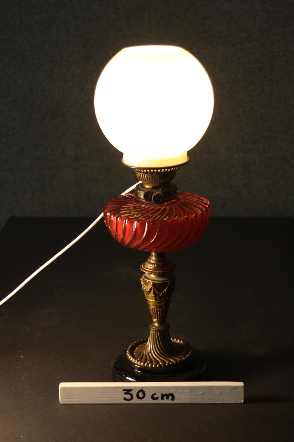 A Victorian oil lamp converted to electricity, with a spherical milk glass shade and a gadrooned red - Image 2 of 4