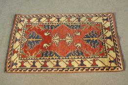 A small hand made red ground Chubi rug. L.107 W.69cm.