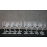 Two sets of eight cut crystal wine glasses with stylised foliate design, each set with a different