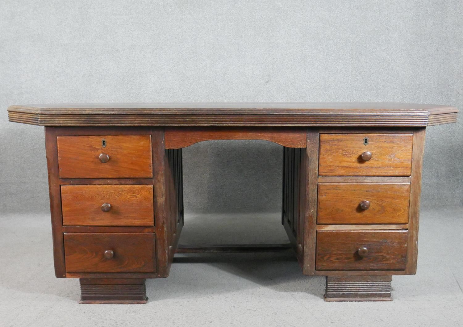 A vintage pedestal desk, the rectangular top with canted corners and a reeded edge, both pedestals