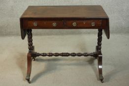 A George III design mahogany sofa table, the top with two drop leaves over two short drawers, on