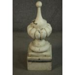 A large painted carved decorative finial with gadrooned design on a pedestal base. (two sections