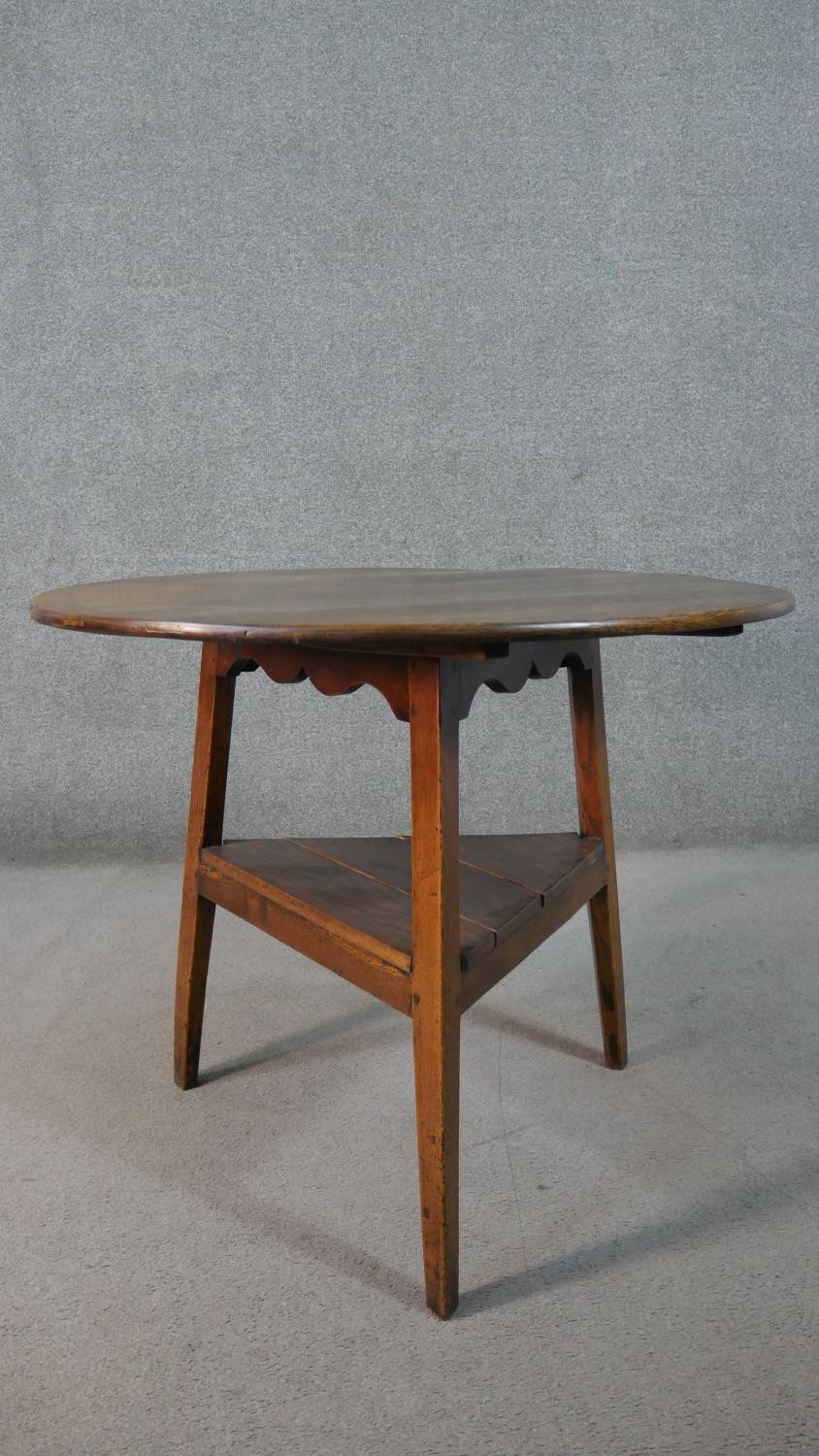 A 19th century country oak cricket table with shaped frieze on splay supports united by an - Image 5 of 5