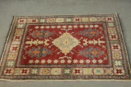 A hand made red ground Chechen Kazak rug. L.150 W.115cm.