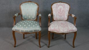 A pair of French walnut Louis XV style fauteuil armchairs, upholstered in differing fabric, with