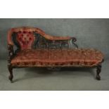 A Victorian rosewood rococo revival chaise longue, upholstered in foliate patterned red silk with