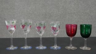 Four Orrefors hand painted glasses along with a green and cranberry glass wine glass. H.16 Diam.