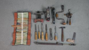 A collection of vintage tools, including a roll of carved pottery tools, various clamps and other