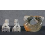 A pair of Chinese carved soapstone Foo dogs on rectangular stands along with an African stone
