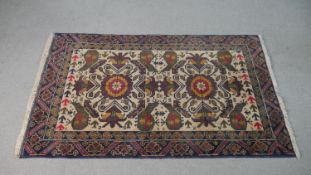 A Zekhani Belouch rug with repeating floral motif on a biscuit ground. L.140 W.90cm