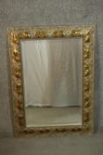 A contemporary silvered and parcel gilt mirror, with a bevelled rectangular mirror plate, the