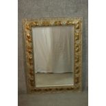 A contemporary silvered and parcel gilt mirror, with a bevelled rectangular mirror plate, the