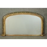 A Victorian giltwood overmantel mirror, of rounded arch form, with a painted floral border. H.51 W.