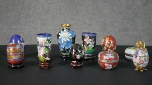 A collection of Chinese cloisonne enamel boxes and vases, each with a different floral design,