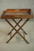 A 19th century mahogany butlers tray, with a rectangular top and hand holds, on a X frame folding