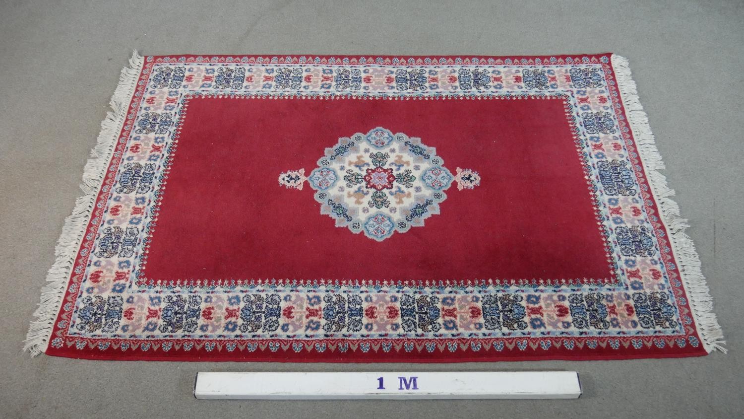 A hand made Moroccan rug with central floral medallion on a burgundy ground within a foliate border. - Image 2 of 9