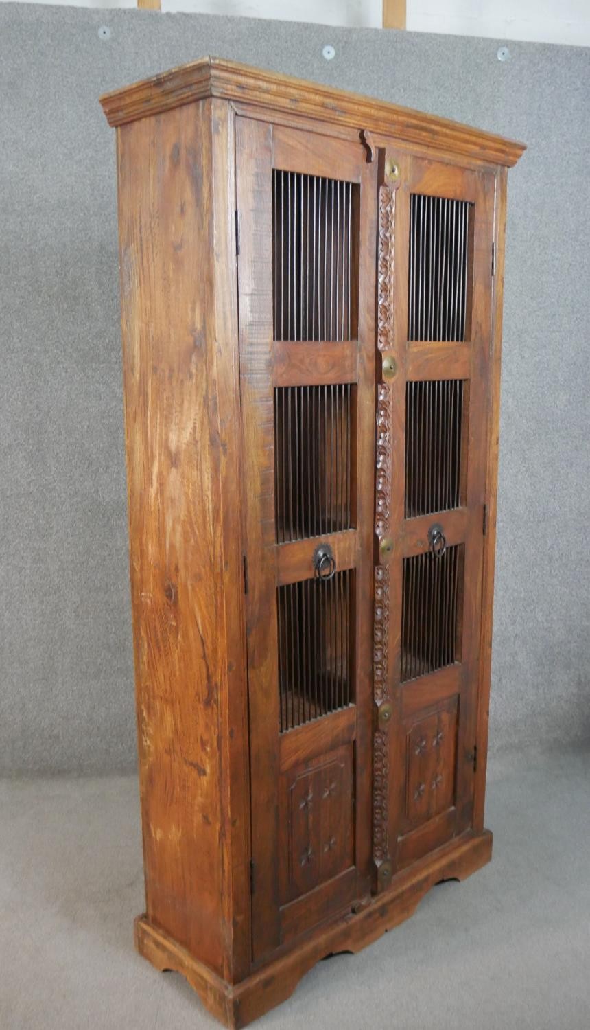 A 20th century Indian sheesham bookcase, the two doors with metal spindle panels, opening to - Image 8 of 8