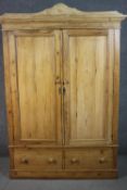 A northern or central European pine wardrobe, with a pair of cupboard doors over a pair of short
