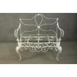 A white painted French wrought iron two seater garden bench, with open arms, on cabriole legs.