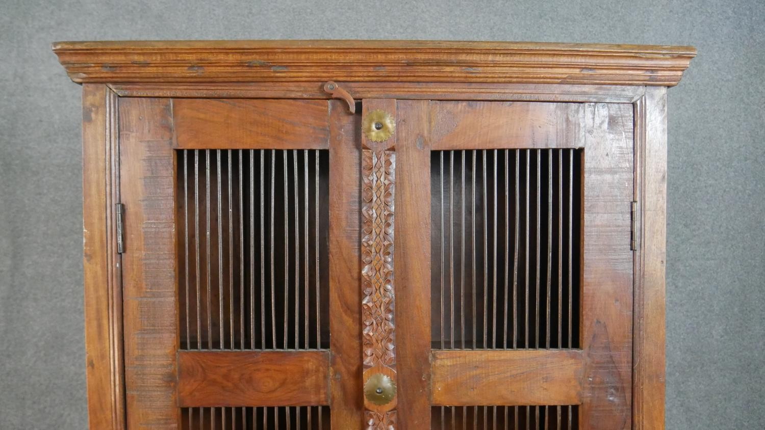 A 20th century Indian sheesham bookcase, the two doors with metal spindle panels, opening to - Image 2 of 8