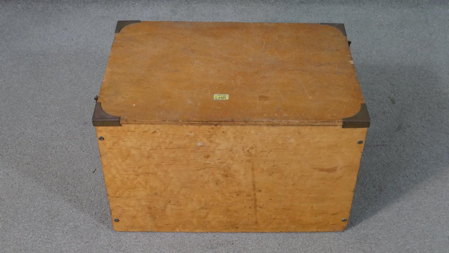 A stained hardwood lidded box with brass fittings containing eight maple veneered framed