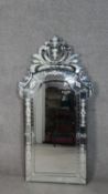 A Venetian style pier mirror with shaped bevelled plate within etched foliate cresting and