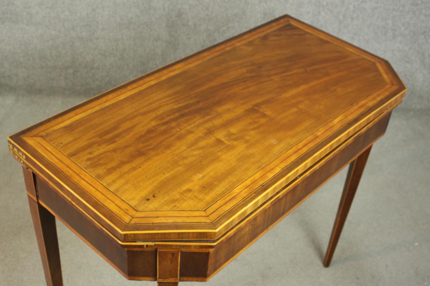 A Sheraton style mahogany card table, the rectangular top with canted corners, crossbanded with - Image 4 of 10
