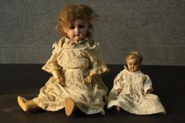 Two 19th century dolls. One smaller in size with a painted mache head and plaster hands and feet,