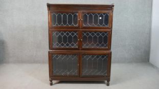 A 20th century Minty of Oxford three tier stacking bookcase, each tier with two leaded glass