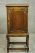An early 20th century Jacobean style oak cabinet, with a geometric panelled cupboard door