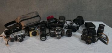 A collection of approximately sixteen vintage cameras, lenses and accessories including an Asahi