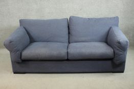 A contemporary two seater sofa, upholstered in blue fabric, the angular frame with loose cushions to
